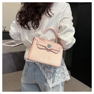 Detail of pink snake-embossed handbag with silver lock and white lace bow decoration
