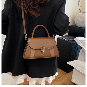 Détail d'un sac bandoulière en cuir marron avec textures tressées et fermoir doré