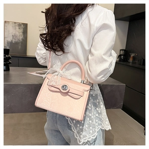 Detailed shot of pink snake pattern kelly bag with large white lace bow and silver lock