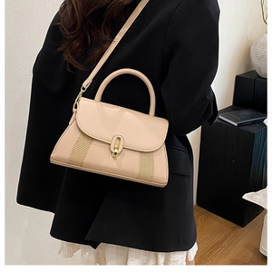Détail du sac beige avec texture tressée et fermoir doré porté par un mannequin