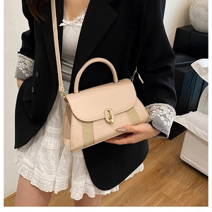 Vue latérale détaillée du sac bandoulière beige avec empiècements rayés et boucle en métal