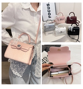 Detailed view of fashion handbag with lace ribbons and secure metal rotating lock