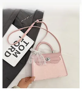 Detail of pink snake embossed leather bag with metal lock and lace bow decoration