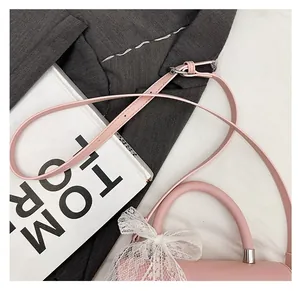 Detailed close-up of a pink handbag leather shoulder strap with metal adjustment buckle