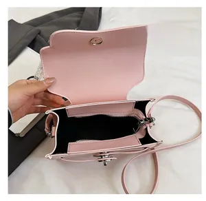 Detail view of pink crossbody bag interior with zip pocket and metal magnetic closure