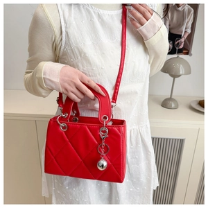 Detailansicht der roten gesteppten Handtasche mit Silberanhänger und eleganten Griffen