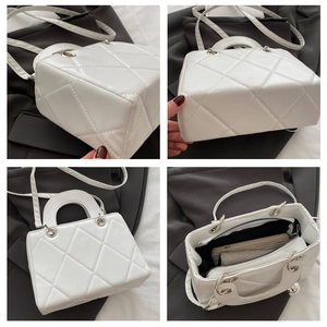 Detail view showing white quilted pattern, interior space and smooth metal handle rings