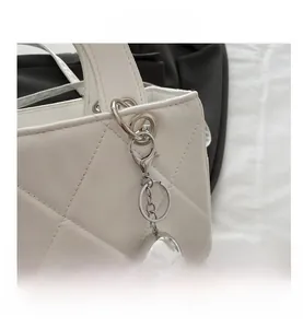 Close-up of white quilted leather texture and silver metallic ball charm detail