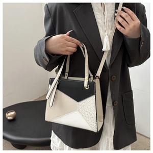 Detail showing geometric patchwork design and woven texture on a stylish crossbody bag