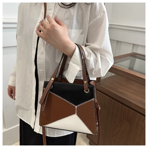 Detailed view of tricolor geometric bag with white stitching and woven texture accents