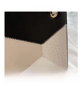Detail von Kontrastnähten und goldener Metallöse auf einer modischen Damen-Handtasche
