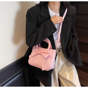 Close-up of pink handbag featuring a large 3D bow design and Fashion & Bags text