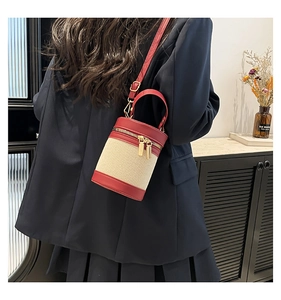 Contrast bucket bag detail with red leather trim and white canvas on a navy blazer
