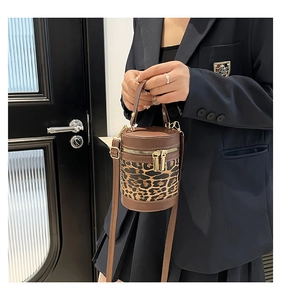 Detail view of the brown leather and leopard print bucket bag with gold hardware