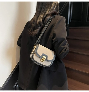 Detail view of small saddle bag showing canvas leather stitching and gold hardware