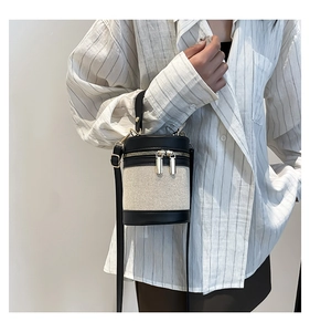 Detailed close-up of a color-block linen bucket bag with premium gold dual zippers
