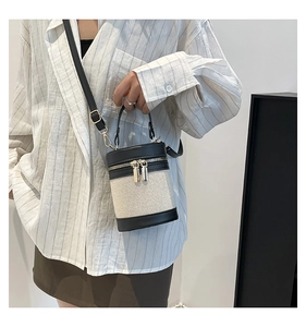 Detail of color-block bucket bag featuring canvas patchwork and black leather trim