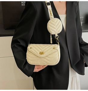 Detail of cream V-quilted crossbody bag with gold twist lock and wide woven strap