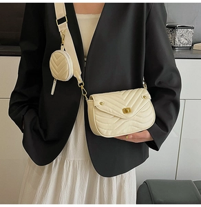 Detail of cream quilted crossbody bag featuring V-stitch pattern and detachable coin purse