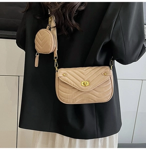 Detail of beige quilted crossbody bag with wide strap and matching round coin purse pouch