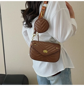 Detail of brown quilted crossbody bag with gold twist lock and round coin purse accessory