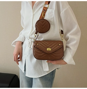 Brown chevron-quilted crossbody bag detail with wide strap and round coin purse accessory