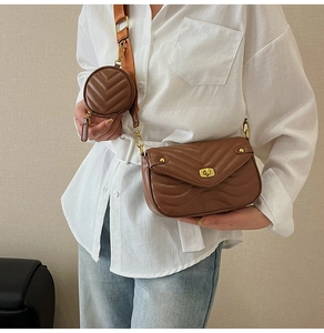 Close-up of brown V-quilted crossbody bag with gold lock and mini round coin pouch detail