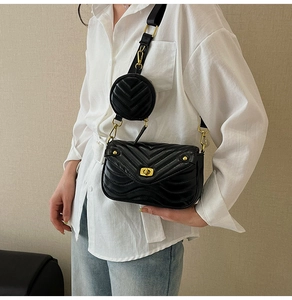 Detail of black chevron quilted crossbody bag with gold twist lock and mini round coin purse