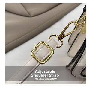 Detail of adjustable cream leather strap with gold lobster clasp and metallic hardware