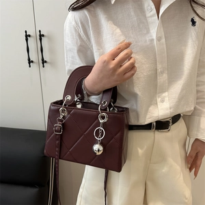 Gesteppte burgunderrote Handtasche mit Silberanhängern und passendem Leder-Schultergurt