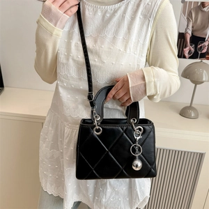 Schicke schwarze Stepptasche mit silbernem Kugelanhänger und verstellbarem Schultergurt