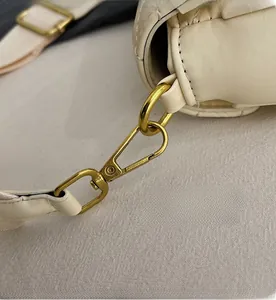 Detail of high-quality gold metal lobster clasp and quilted texture on small square bag