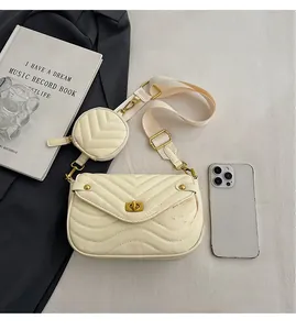 Detail of cream quilted crossbody bag with matching round coin purse and wide strap