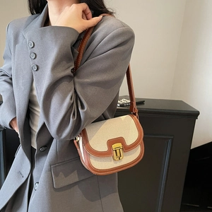 Retro canvas and brown leather crossbody saddle bag with gold buckle on model