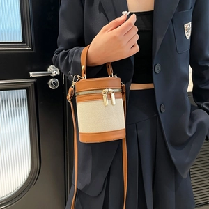 Linen canvas and brown leather cylinder bucket bag with dual zippers for summer 2025