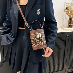 Fashionable leopard print linen bucket bag with brown leather trim and gold zippers