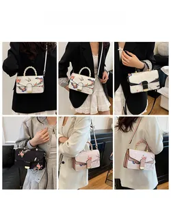 Detailansichten der Blumen- und Schmetterlingsstickerei auf Handtasche mit Webgriffen