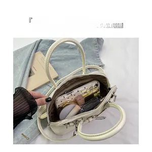 Top view of white shell bag showing spacious interior with brown striped lining and pockets