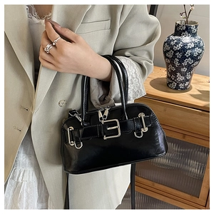 Detail of vintage black shell bag with silver buckle and sleek glossy leather finish