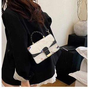 Detail der Handtasche mit Blumen Schmetterling Druck und gewebtem Griff mit Golddekor
