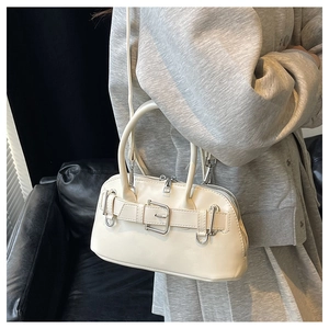 Detailed shot of the cream shell bag featuring a chic buckle design and silver hardware