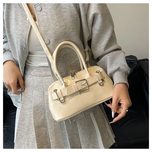 Detail of beige shell bag with vintage silver buckle and rounded handle design