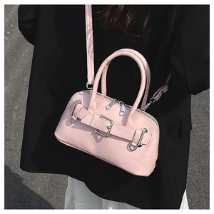 Detailed view of pink leather shell bag with silver buckle and adjustable shoulder strap