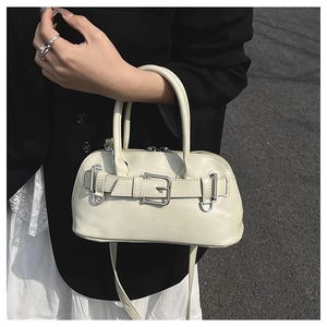 Detail of off-white leather shell bag with silver buckle and smooth grain texture