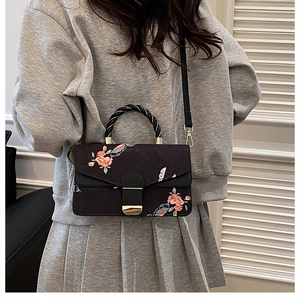 Detail der Handtasche mit Blumendruck, rosa Blüten und schwarzem Webgriff