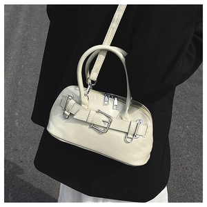 Close-up of cream shell bag with belt buckle detail worn with a black blazer
