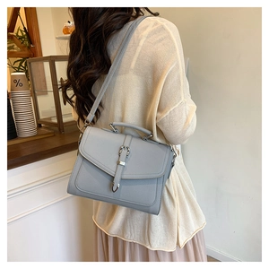 Detailed macro view of light gray lychee grain leather envelope bag with strap