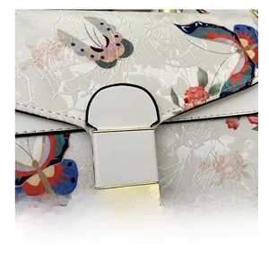 Detailaufnahme der Handtasche mit Blumen Schmetterlingsdruck und goldenem Verschluss