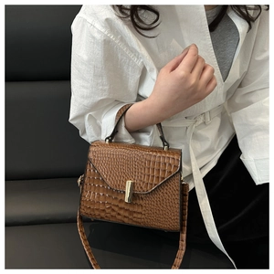 Vue détaillée d'un sac à main marron à motif crocodile avec boucle en métal et bandoulière