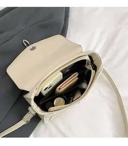 Top-down view of the beige crossbody bag interior showing organized multiple compartments